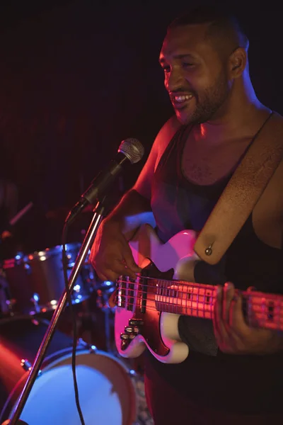 Cantante tocando con guitarra en discoteca — Foto de Stock