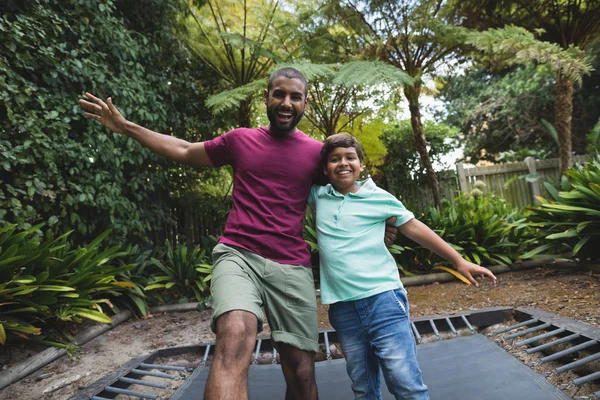 Батько і син стрибають на батуті — стокове фото