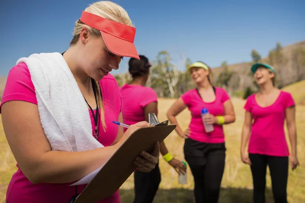 Entrenadora escribiendo en portapapeles —  Fotos de Stock