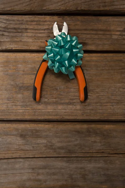 Pliers with ribbon on table — Stock Photo, Image