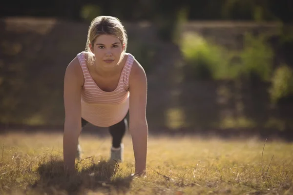 Woman exercising during obstacle course — Stock Photo, Image