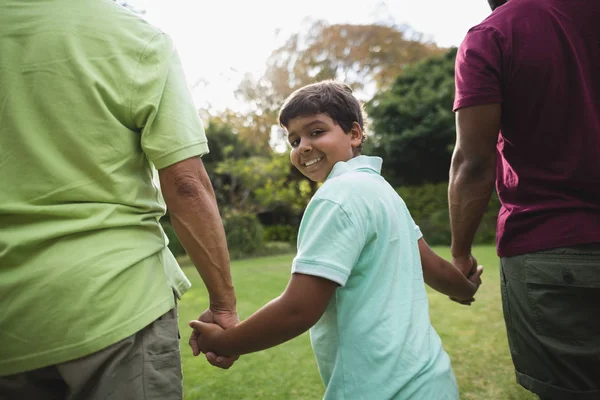 Niño caminando con padre y abuelo —  Fotos de Stock