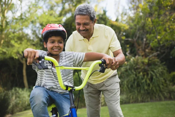 Nonno che assiste il nipote in bicicletta — Foto Stock