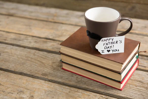 Groeten met kopje koffie op stapel boeken — Stockfoto