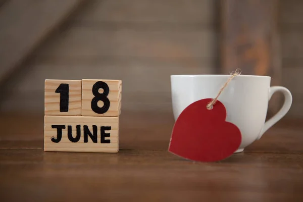 Fecha del calendario por taza de café con forma de corazón —  Fotos de Stock