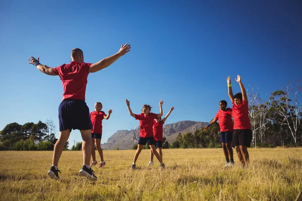 Trainer opleiding kinderen in het kamp van de laars — Stockfoto