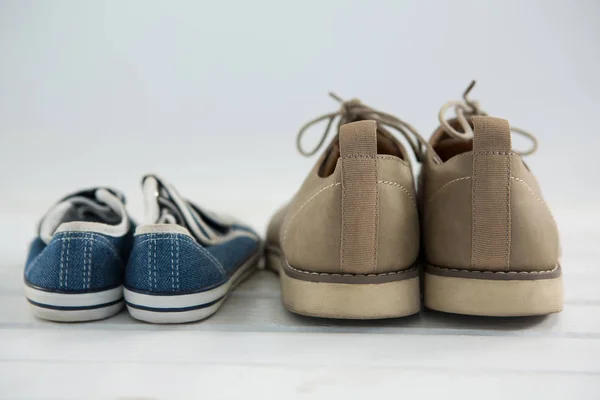 Zapatos en piso blanco contra pared —  Fotos de Stock