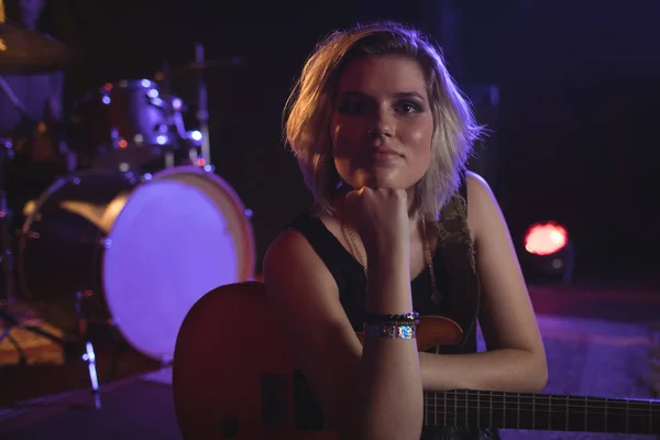 Kobiece gitarzysta siedzi w klubie nocnym — Zdjęcie stockowe