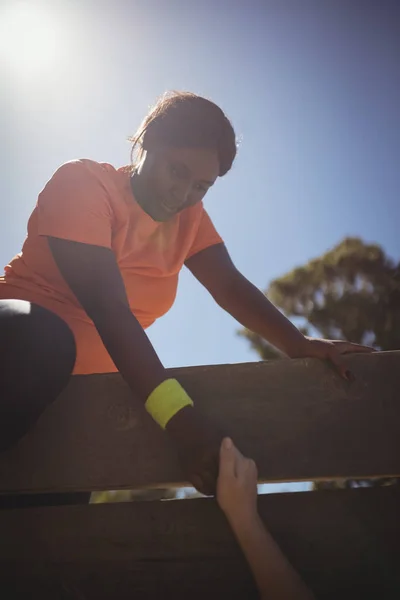 Trainer assistere donna in parete di legno — Foto Stock