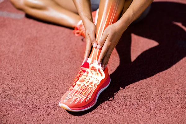 Atleta donna seduta in pista con dolore — Foto Stock