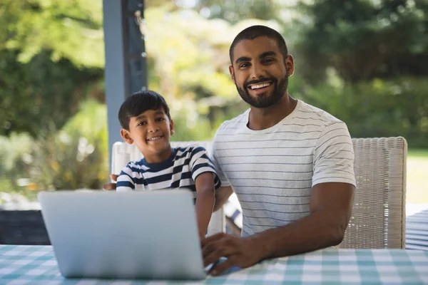Homem com filho usando laptop na mesa — Fotografia de Stock