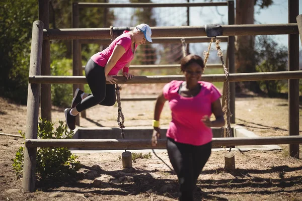 Mulheres se exercitando durante o curso de obstáculos — Fotografia de Stock