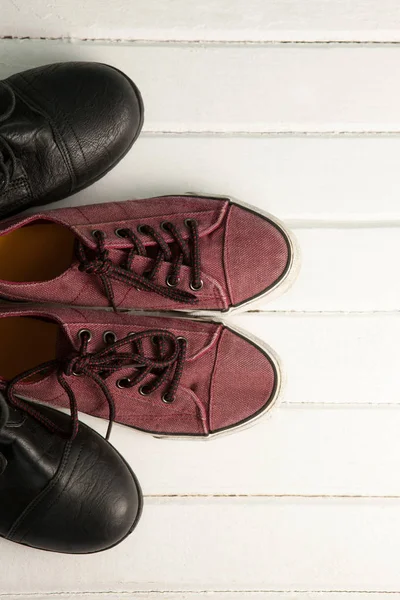 Коричневые мокасины и черные туфли на полу — стоковое фото