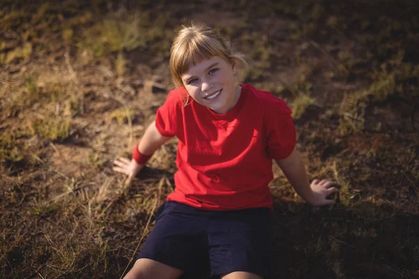 Flicka avkopplande på gräs under hinderbana — Stockfoto