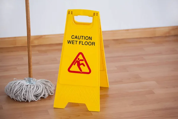 Mop with wet floor caution sign — Stock Photo, Image