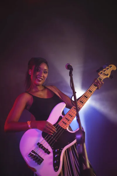 Singer holding guitar on stage — Stock Photo, Image