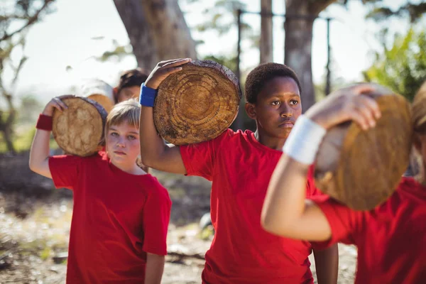 Niños llevando tronco de madera — Foto de Stock