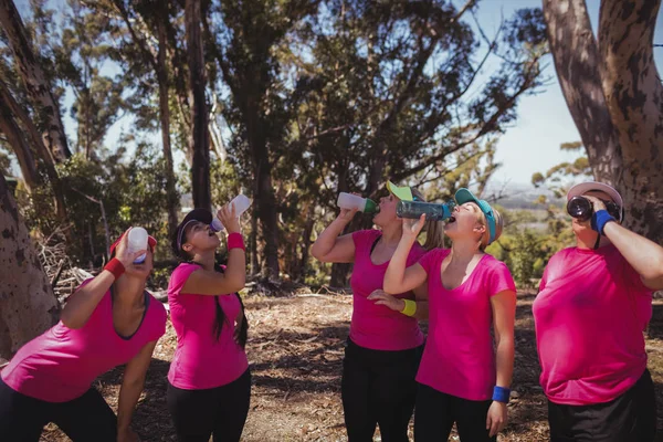 Mujeres bebiendo agua en el campo de entrenamiento —  Fotos de Stock