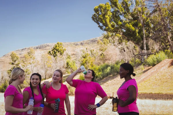 Mujeres bebiendo agua en el campo de entrenamiento —  Fotos de Stock