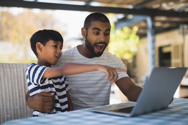 Döbbenve, ember fia látszó-on laptop-tábla — Stock Fotó