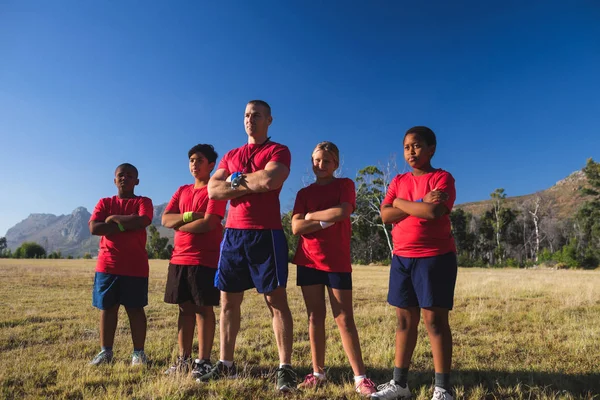 Pelatih dan anak-anak berdiri dengan lengan disilangkan — Stok Foto