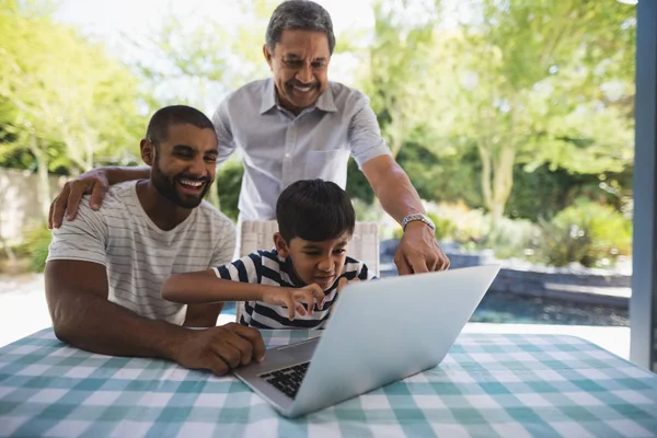 Família multi-geração usando laptop no alpendre — Fotografia de Stock