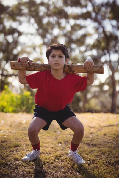 Garçon exercice avec log pendant la course d'obstacles — Photo