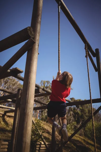 Determined girl climbing rope — Stock Photo, Image