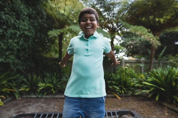 Lycklig pojke hoppar på studsmatta — Stockfoto