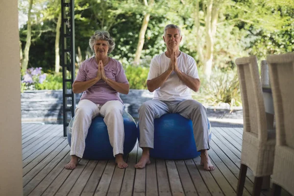 Äldre par mediterar på träningsbollar — Stockfoto