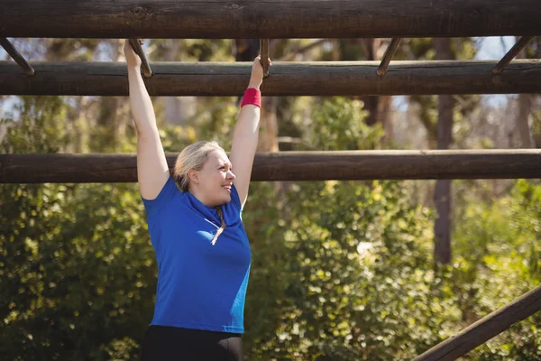 Vastberaden vrouw uitoefenen op monkey bar — Stockfoto