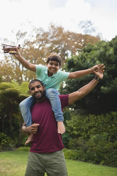 Allegro padre piggybacking figlio — Foto Stock