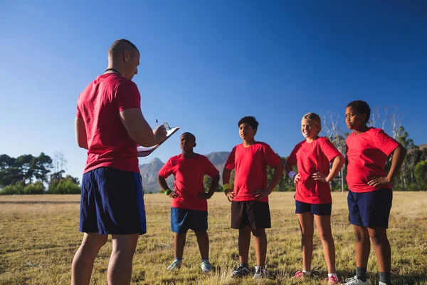 Trainer instrueren van kinderen in het kamp van de laars — Stockfoto