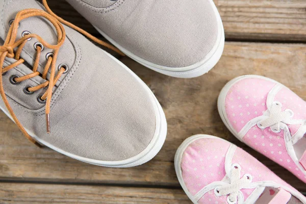 Roze en bruin schoenen op houten vloer — Stockfoto
