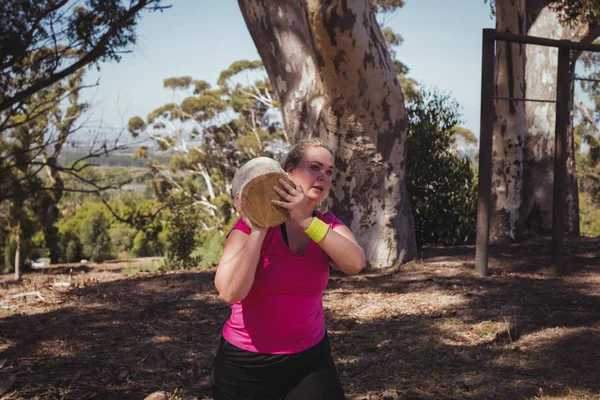 女人携带重型木日志 — 图库照片