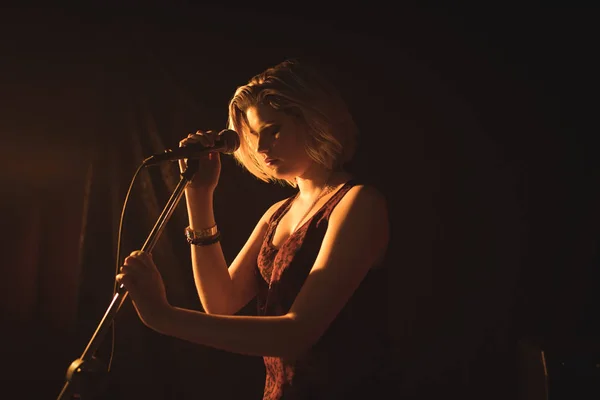 Singer holding microphone in nightclub — Stock Photo, Image