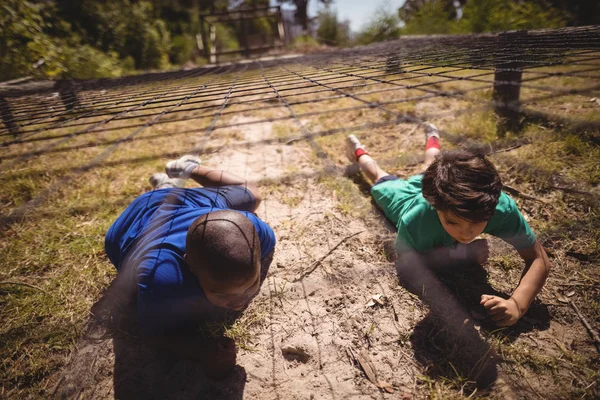 Niños arrastrándose bajo la red — Foto de Stock