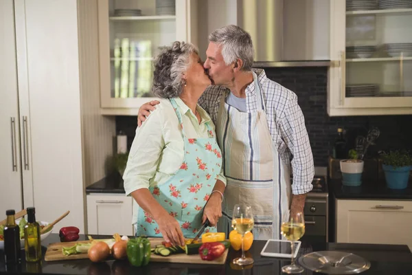 Senior pareja besos mientras cocinar — Foto de Stock