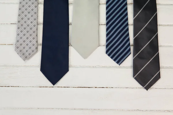 Olika slipsar på träbord — Stockfoto
