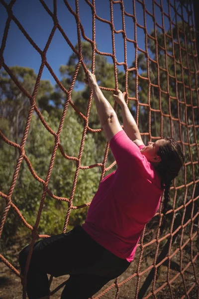 Mulher determinada escalando uma rede — Fotografia de Stock