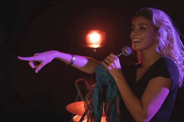 Cantante apuntando mientras realiza en discoteca — Foto de Stock