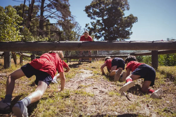 Niños arrastrándose bajo la red — Foto de Stock