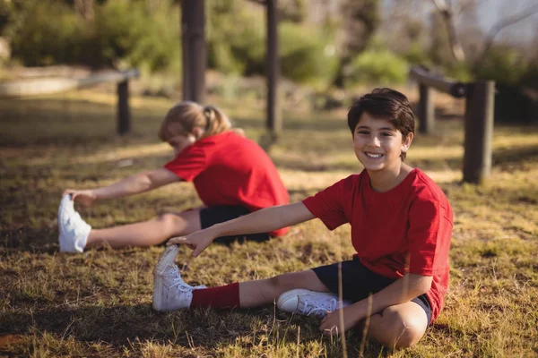 Glada barn utför stretching motion — Stockfoto