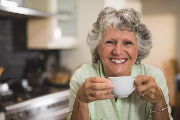 Äldre kvinna anläggning cup — Stockfoto