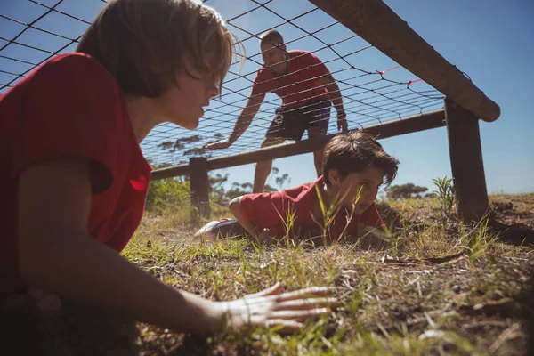 Niños arrastrándose bajo la red — Foto de Stock