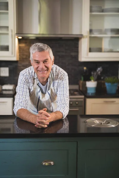 Homem sênior usando avental na cozinha — Fotografia de Stock