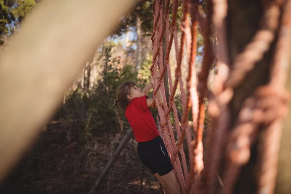 Ragazza arrampicata su una rete durante il percorso ad ostacoli — Foto Stock