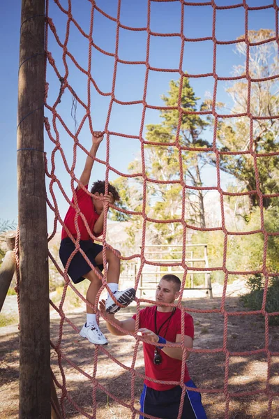 Treinador assistindo menino para subir — Fotografia de Stock