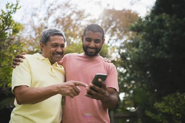 Far och son med mobiltelefon — Stockfoto