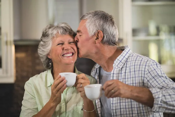 Homem beijando esposa e beber café — Fotografia de Stock